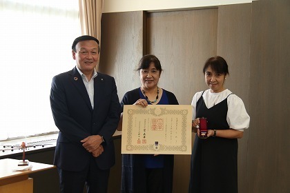 写真：褒章と賞状を手にする竿下純子さんと市長