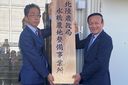 写真：事業所の看板を掲げる石川局長と市長