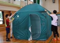 写真：避難所開設訓練で防災テントを張る様子